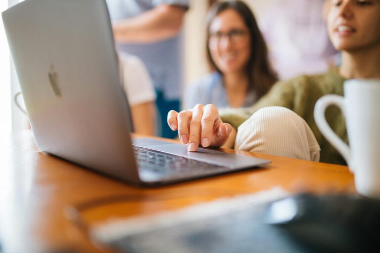 Two people looking at a laptop together drinking coffee